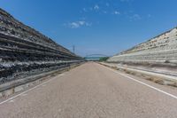 two rows of concrete are in the middle of a desert road, one with the other without