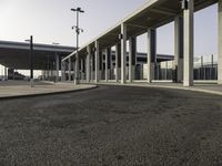 a deserted street under a large walkway on top of an airport building to enter a terminal