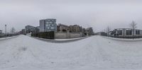 a fish eye view of the snow and buildings in winter time with snow piled to ground