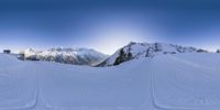 a snowy mountain with skis and tracks all over it and some trees in the background