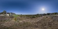 a 360 view of some hills with trees on each side of it and the sun in the sky above them