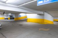 the car park has yellow and white painted flooring and a blue sign that reads sorren