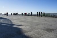 a group of people that are on a roof top with a kite in the sky