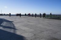 a group of people that are on a roof top with a kite in the sky