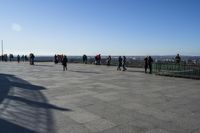 a group of people that are on a roof top with a kite in the sky