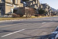 a paved street that has no traffic in it, with a line running parallel to the sidewalk