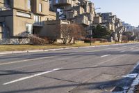 a paved street that has no traffic in it, with a line running parallel to the sidewalk