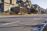 a paved street that has no traffic in it, with a line running parallel to the sidewalk