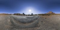 a view of a desert with the sun shining brightly on it, and on a clear day