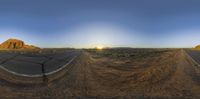 an image of the sun setting on a desert road as seen through a fisheye lens