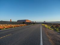 an empty, open road stretches from the mountains to the horizon in the desert during sunset