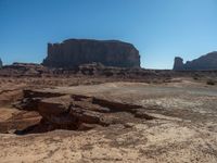 large expanse of rock formations at the base of an area of desert terrain with sparse plants and dirt