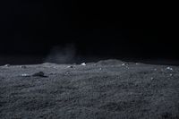 rocks sit alone on top of some grass on the surface of space, lit by spotlight from bright spotlights