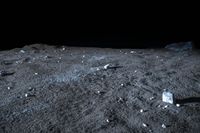 a black background shows some small rocks in a desert with dark sky behind it and a large white rock on the ground