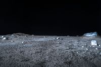 a view of rock and boulders on a dark moon surface, taken from a low angle