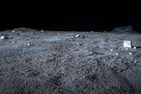 a view of rock and boulders on a dark moon surface, taken from a low angle