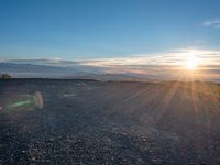 the sun shines on an empty rocky road in iceland, where the beach is next to the water