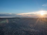 the sun shines on an empty rocky road in iceland, where the beach is next to the water