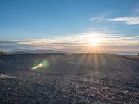 the sun shines on an empty rocky road in iceland, where the beach is next to the water