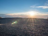 the sun shines on an empty rocky road in iceland, where the beach is next to the water