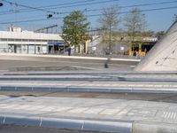 a man is crossing an empty street in the morning with a skateboard on the ground