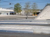 a man is crossing an empty street in the morning with a skateboard on the ground