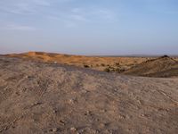 a truck on a dirt road in the desert with rocks and stones on the ground