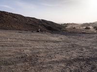 a truck on a dirt road in the desert with rocks and stones on the ground