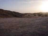 a truck on a dirt road in the desert with rocks and stones on the ground