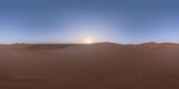 a desert with sand dunes and a sun setting in the background on a clear day