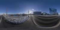 a photo of the sun shining through buildings in the city of moscow, russia, and a view of a half pipe on a parking lot of a city