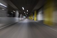 motion blurry of a dark tunnel that leads into a building with a green light