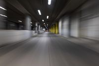 motion blurry of a dark tunnel that leads into a building with a green light