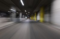 motion blurry of a dark tunnel that leads into a building with a green light