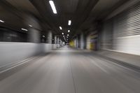 motion blurry of a dark tunnel that leads into a building with a green light