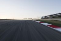 a speed track with motion bluring across it at dusk, with a blue sky