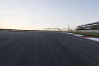 a speed track with motion bluring across it at dusk, with a blue sky