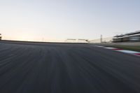 a speed track with motion bluring across it at dusk, with a blue sky