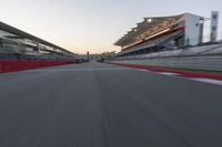 a racing track with the start in motion of it at dusk, motion blurry