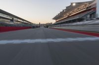 a racing track with the start in motion of it at dusk, motion blurry