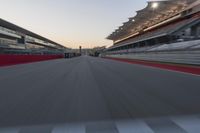 a racing track with the start in motion of it at dusk, motion blurry