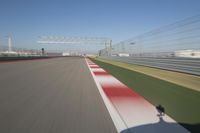 the red line is in motion on the track, with blurred background and blurry images of man driving it