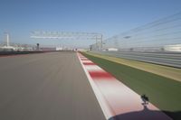 the red line is in motion on the track, with blurred background and blurry images of man driving it