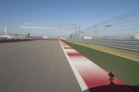 the red line is in motion on the track, with blurred background and blurry images of man driving it