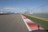 the red line is in motion on the track, with blurred background and blurry images of man driving it