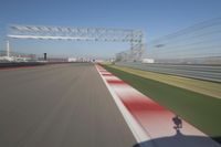 the red line is in motion on the track, with blurred background and blurry images of man driving it