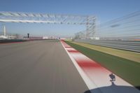 the red line is in motion on the track, with blurred background and blurry images of man driving it