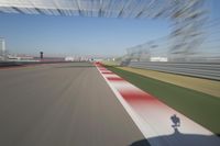 the red line is in motion on the track, with blurred background and blurry images of man driving it