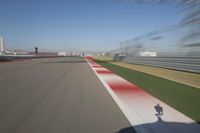 the red line is in motion on the track, with blurred background and blurry images of man driving it