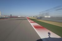 the red line is in motion on the track, with blurred background and blurry images of man driving it